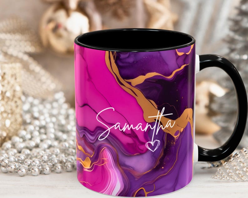 Pode incluir: Uma caneca de cer&acirc;mica rosa e roxa com al&ccedil;a preta e um design de redemoinho dourado. A caneca tem o nome "Samantha" escrito nela em it&aacute;lico branco.