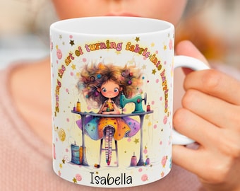 May include: White ceramic mug with a colorful illustration of a girl sewing. The text "Sewing the art of turning fabric into happiness" is printed around the girl. The name "Isabella" is printed at the bottom of the mug.