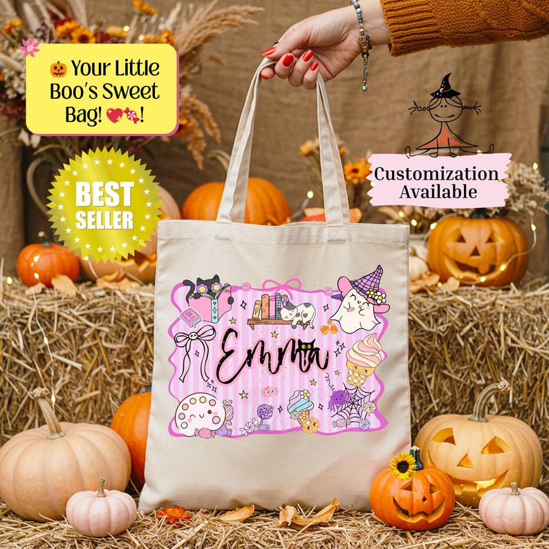 Peut inclure: Sac fourre-tout en toile beige avec un motif sur le th&egrave;me d'Halloween. Le motif comprend une banni&egrave;re rose avec le nom "Emma", ainsi que des chats, des fant&ocirc;mes et des bonbons de dessins anim&eacute;s. Le sac est entour&eacute; de citrouilles et de foin.