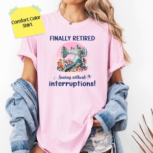 May include: Pink t-shirt with the text "FINALLY RETIRED Sewing without interruptions!" and a colorful illustration of a sewing machine with fabric and thread.
