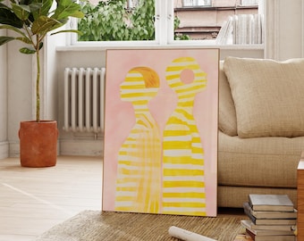 May include: Abstract art print featuring two figures with yellow and white stripes on a pink background. The print is framed and hanging on a white wall in a living room.