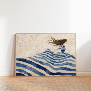 May include: Watercolor art print featuring a woman in a blue and white striped dress, seemingly floating on blue waves. The artwork has a gold frame and a speckled background, creating a serene and whimsical feel.