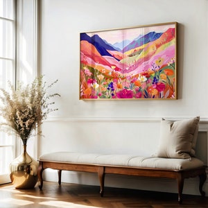 K&ouml;nnte beinhalten: Ein farbenfrohes abstraktes Gem&auml;lde einer Berglandschaft mit einem Feld voller Blumen im Vordergrund. Das Gem&auml;lde ist in Gold gerahmt und h&auml;ngt an einer wei&szlig;en Wand.