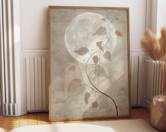Puede incluir: Una impresión artística enmarcada con una gran luna pálida sobre un fondo apagado de tonos neutros. Delicados elementos botánicos en forma de vid, con hojas en tonos beige y marrón, se superponen a la luna. El marco es de color madera clara.
