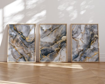 May include: Three framed abstract art prints with a marbleized design in shades of gray, white, and gold.