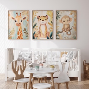 Può includere: Tre stampe incorniciate di animali ad acquerello: una giraffa, un leopardo e una scimmia. La giraffa ha macchie arancioni e un collo lungo. Il leopardo ha macchie marroni. La scimmia è marrone e seduta su un ramo. Le stampe sono sopra una culla bianca e mobili per bambini.