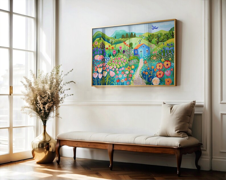 May include: A colorful painting of a blue house in a field of flowers. The house has a white door and a red roof. The flowers are in shades of pink, red, yellow, and blue. The painting is framed in gold.