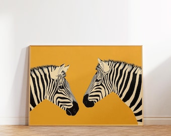 Puede incluir: Una impresión artística enmarcada con dos cabezas de cebra enfrentadas. Las cebras están representadas en blanco y negro sobre un fondo amarillo mostaza. La obra de arte se exhibe en una habitación con suelo de madera.