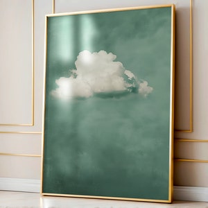 Puede incluir: Una impresión enmarcada de una sola nube blanca sobre un cielo azul verdoso. La nube está en el centro de la imagen y está ligeramente descentrada hacia la izquierda.