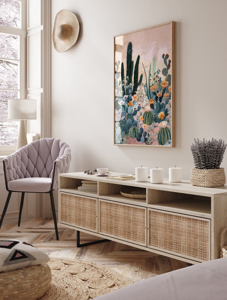 Pu&ograve; includere: Una consolle multimediale in legno chiaro con tre ante in rattan intrecciato e ripiani aperti. La consolle &egrave; decorata con tre candele bianche, una piccola ciotola bianca e un vassoio intrecciato. Una grande stampa incorniciata di un paesaggio desertico con cactus e fiori &egrave; appesa al muro dietro la consolle.