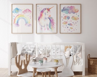 Puede incluir: Una cuna blanca con impresiones de acuarela con temática de arcoíris, unicornio y nubes colgadas encima. La cuna está decorada con almohadas y una manta blanca. Una pequeña mesa blanca con cuatro sillas está delante de la cuna. Las sillas tienen forma de ciervo y conejo.