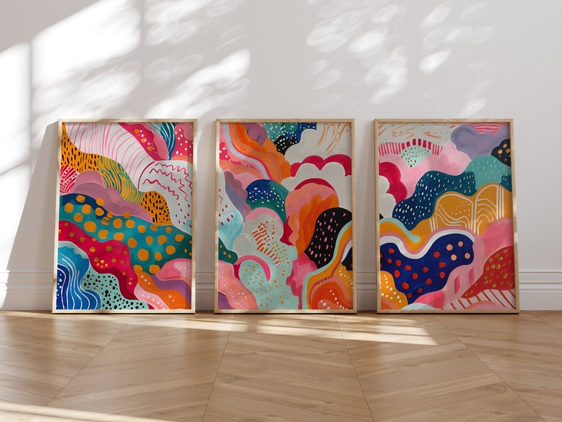 May include: Three framed abstract paintings with colorful, organic shapes and patterns. The paintings are in a modern style and feature a variety of colors, including pink, blue, green, yellow, and orange.