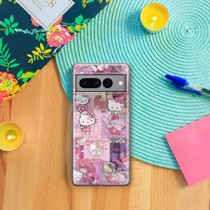 Op de afbeelding: Een transparante telefoonhoes met een roze Hello Kitty-ontwerp. De hoes heeft een collage van Hello Kitty-afbeeldingen, waaronder harten, vlinders en de tekst "Hello Kitty".