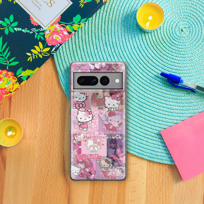 Op de afbeelding: Een transparante telefoonhoes met een roze Hello Kitty-ontwerp. De hoes heeft een collage van Hello Kitty-afbeeldingen, waaronder harten, vlinders en de tekst "Hello Kitty".
