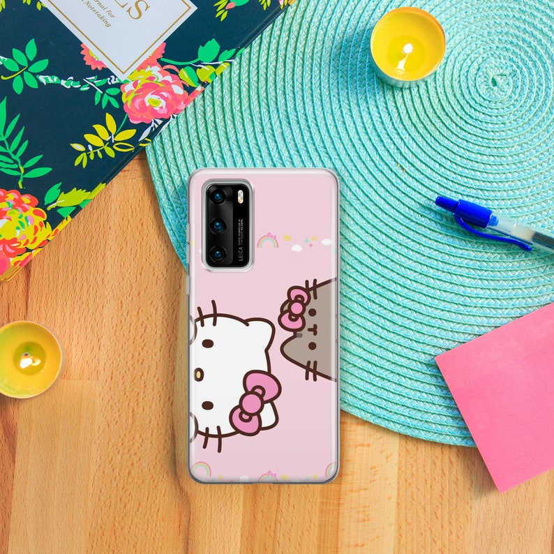 K&ouml;nnte beinhalten: Eine rosa Handyh&uuml;lle mit einem Hello Kitty und Pusheen Katzen-Design. Die H&uuml;lle ist transparent und zeigt das Objektiv der Handykamera.