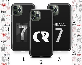 Puede incluir: Tres fundas de teléfono negras con diseños blancos. La primera funda tiene el número 7 y el nombre "CRISTIANO" impreso en ella. La segunda funda tiene el número 7 y las letras "CR" impresas en ella. La tercera funda tiene el número 7 y el nombre "RONALDO" impreso en ella.
