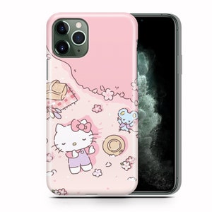 May include: A pink iPhone case with a Hello Kitty design. The case features Hello Kitty laying on a pink blanket with a picnic basket, a hat, and a small blue mouse. The background is a pink and white floral pattern.