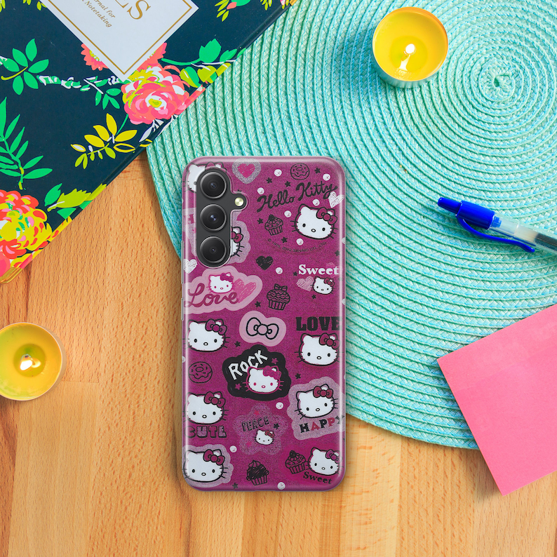 Pu&ograve; includere: Una custodia per telefono rosa Hello Kitty con finitura glitter. La custodia presenta una variet&agrave; di immagini e frasi di Hello Kitty, tra cui "Hello Kitty", "Sweet", "Love", "Rock", "Cute", "Peace", "Happy" e "Sweet".