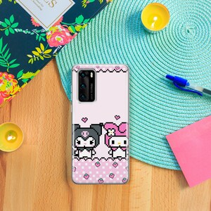 K&ouml;nnte beinhalten: Eine rosa und wei&szlig;e Handyh&uuml;lle mit einem Pixelbild von Hello Kitty und einem schwarz-wei&szlig;en Charakter mit Schleife. Die H&uuml;lle hat ein rosa und wei&szlig;es Karomuster mit rosa Erdbeeren.