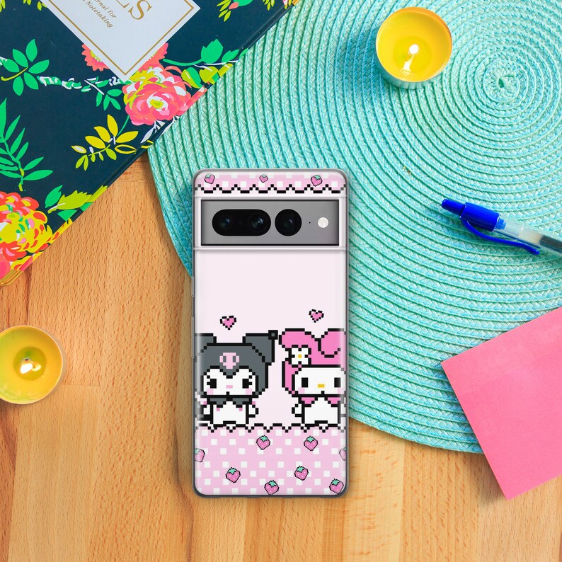 Pode incluir: Uma capa transparente para telefone com um fundo xadrez rosa e branco. A capa apresenta uma imagem pixelada da Hello Kitty e um personagem preto e branco com um la&ccedil;o.