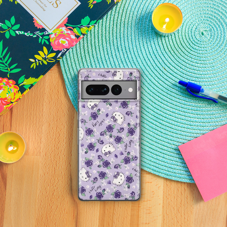 K&ouml;nnte beinhalten: Eine transparente Handyh&uuml;lle mit lila Hintergrund und einem sich wiederholenden Muster aus Hello Kitty-Figuren und lila Rosen. Die H&uuml;lle hat einen Ausschnitt f&uuml;r die Kamera.
