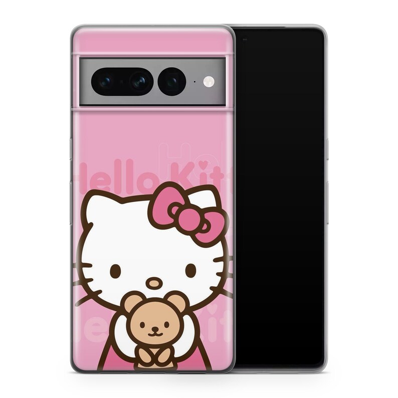 Puede incluir: Una funda de tel&eacute;fono rosa con un dise&ntilde;o de Hello Kitty. Hello Kitty est&aacute; sosteniendo un osito de peluche. La funda tiene un recorte para el objetivo de la c&aacute;mara.