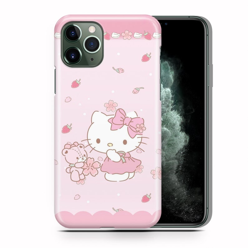 May include: Pink iPhone case with a Hello Kitty design. Hello Kitty is wearing a pink dress and a pink bow. She is holding a small pink bear. The background is pink with white flowers and strawberries.