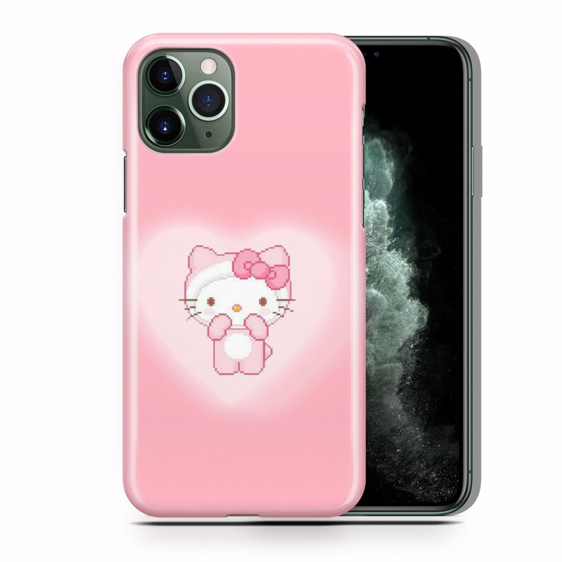 Puede incluir: Una funda de tel&eacute;fono rosa con un dise&ntilde;o de Hello Kitty. La funda tiene un recorte de c&aacute;mara transparente y un contorno blanco alrededor del personaje de Hello Kitty.