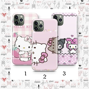 May include: Three pink iPhone cases with different Hello Kitty designs. The first case features Hello Kitty holding a strawberry, the second case features Hello Kitty and a brown cat, and the third case features Hello Kitty and My Melody in pixel art.