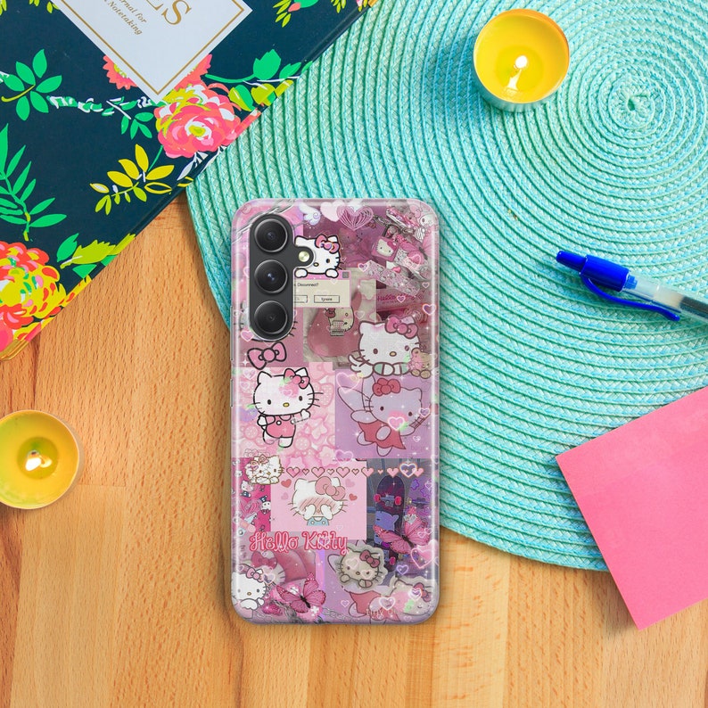 Op de afbeelding: Een transparante telefoonhoes met een roze, wit en zwart Hello Kitty-ontwerp. De hoes heeft een collage van Hello Kitty-afbeeldingen, harten en vlinders. De telefoonhoes is ontworpen voor een smartphone met een drievoudige camera lens.