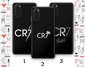 Könnte beinhalten: Drei schwarze Smartphone-Hüllen mit weißem CR7-Schriftzug. Die erste Hülle zeigt CR7 mit einem Blitz, die zweite CR7 mit einer Krone und die dritte CR7 mit einer Unterschrift. Jede Hülle verfügt über einen Ausschnitt für eine Dreifachkamera.