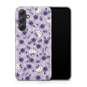 Pu&ograve; includere: Una custodia per telefono viola con un design Hello Kitty che presenta un motivo ripetuto di Hello Kitty e rose. La custodia &egrave; realizzata per un telefono con un obiettivo della fotocamera triplo.