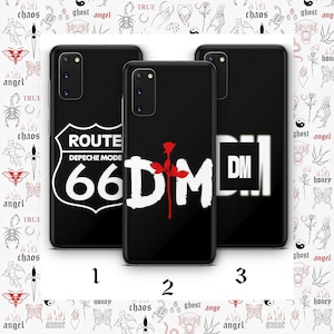 Puede incluir: Tres fundas de teléfono negras con diseños diferentes. La primera funda presenta un letrero blanco de la Ruta 66 con el texto "Depeche Mode" y el número "66". La segunda funda presenta un "DM" blanco con una rosa roja. La tercera funda presenta un "DM" blanco en un cuadrado.