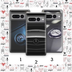Könnte beinhalten: Drei Handyhüllen mit unterschiedlichen Designs. Die erste Hülle ist blau mit einem silbernen Mercedes-Benz-Logo. Die zweite Hülle ist schwarz mit einem silbernen Mercedes-Benz-Logo und einem schwarzen Kühlergrill. Die dritte Hülle ist grau mit einem silbernen Mercedes-Benz-Logo.
