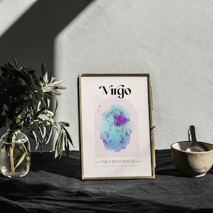 May include: A gold framed print with the word "Virgo" and a watercolor illustration of a woman with flowers in her hair. The text "The Earth Witch" is below the illustration.