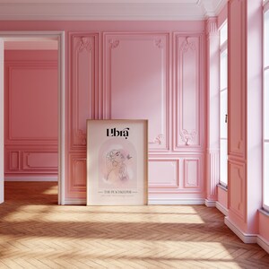 May include: A framed poster with a pink background and a line drawing of a woman with a butterfly. The poster has the text "Libra - The Peacekeeper" at the bottom.
