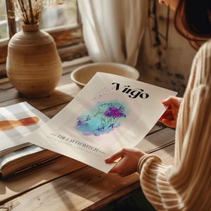 May include: A watercolor illustration of a woman with flowers in her hair. The illustration is in shades of blue, purple, and green. The text "Virgo - The Earth Witch" is printed below the illustration.