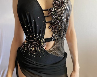 May include: A black dance costume with a sheer black skirt and a sequined bodice. The bodice has a cut-out design and is decorated with rhinestones.