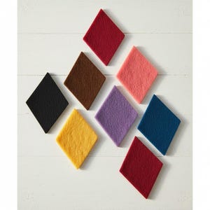 May include: A collection of eight diamond-shaped felt pieces arranged in a scattered pattern. The colours include deep red, brown, black, yellow, light pink, purple, dark blue, and a second shade of red, all featuring a textured, fibrous surface.