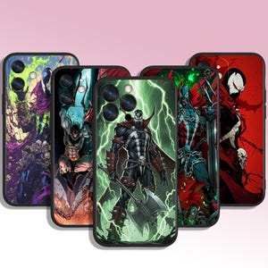 May include: Five black phone cases with comic book art. The cases feature illustrations of a superhero with a red cape, a character with a skull face, and other action-oriented characters. The cases have a black border and are displayed against a pink background.