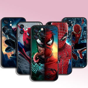 May include: Five different phone cases featuring superhero characters. The cases are black with a variety of colorful designs. One case features Spider-Man, another features Venom, and another features a combination of Spider-Man and Venom. The remaining two cases feature Spider-Man in different poses.