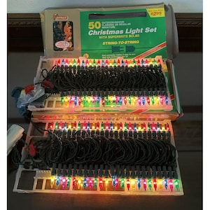 May include: A Christmas light set with 50 miniature multi-color lights. The lights are string-to-string and come in a box with the text "Christmas Light Set" and "Superbrite Bulbs". The box is green and red.