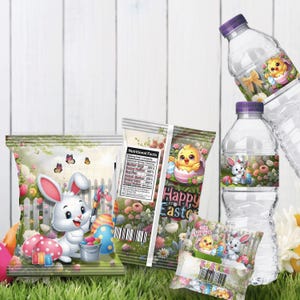 Op de afbeelding: Paasverpakking met een witte konijn, kleurrijke eieren en een kuiken. De afbeelding bevat waterflessen en snackzakken met de woorden "Happy Easter" en "Rice Krispies". De achtergrond heeft een witte hek en bloemen.