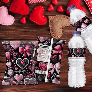 Op de afbeelding: Een Valentijnsarrangement met waterflessen en snackzakken versierd met harten en strikken. De zakken hebben een zwarte achtergrond met roze harten en strikken. Rode en roze vilten harten en een jute hart liggen op een houten oppervlak.