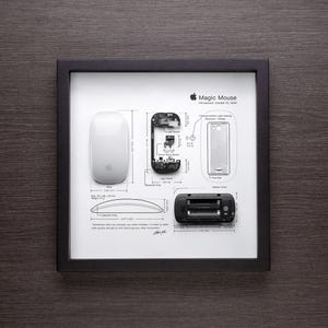 May include: A white Apple Magic Mouse with a diagram of its internal components, including the laser sensor, Bluetooth chip, and battery compartment. The text "Magic Mouse" and "Introduced October 20, 2008" is printed above the diagram.