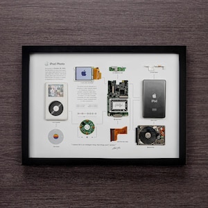 May include: A framed poster showing the disassembled parts of the first generation iPod Photo. The poster includes a quote from Steve Jobs: "I believe life is an intelligent thing. The things that aren't random."