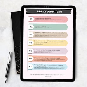 May include: A digital tablet displays "DBT Assumptions" with seven numbered points in a colorful, infographic style. A pen and a black notebook are on the left. The tablet's screen features text about improving lives and changing behavior.