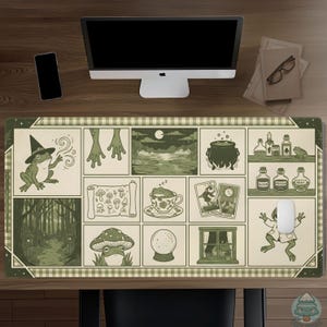 May include: A rectangular desk mat featuring a grid of green and cream illustrations including a frog in a witch hat, a bubbling cauldron, tarot cards, a crystal ball, potion bottles labeled Elixir, Poison, and Newt, and a frog in a teacup.