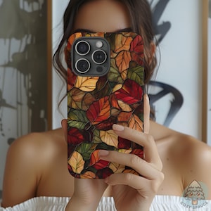 May include: A smartphone case featuring a colorful autumn leaf design. The case displays a mosaic of red, orange, yellow, and green leaves. The case has a glossy finish and is designed to fit a smartphone.