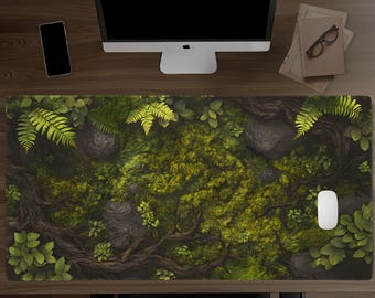 May include: A rectangular desk mat featuring a detailed forest floor print with vibrant green moss, dark brown tree roots, scattered grey rocks, and bright green fern fronds. The mat is positioned on a wooden desk surface.